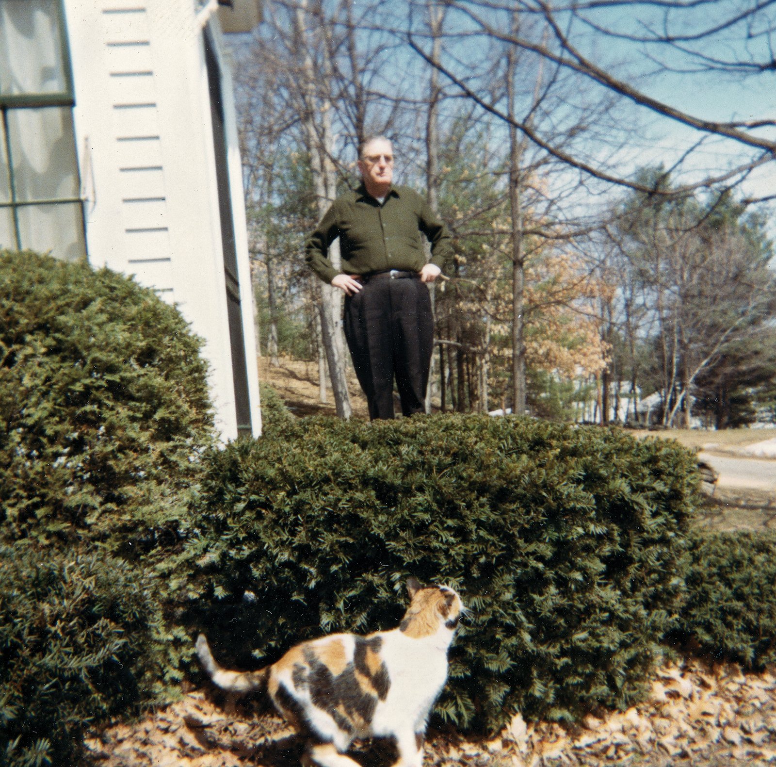 John F. Kennedy out on the front porch of his family home with Spotty, an adopted stray in the foreground. Sturbridge, late 1960s.