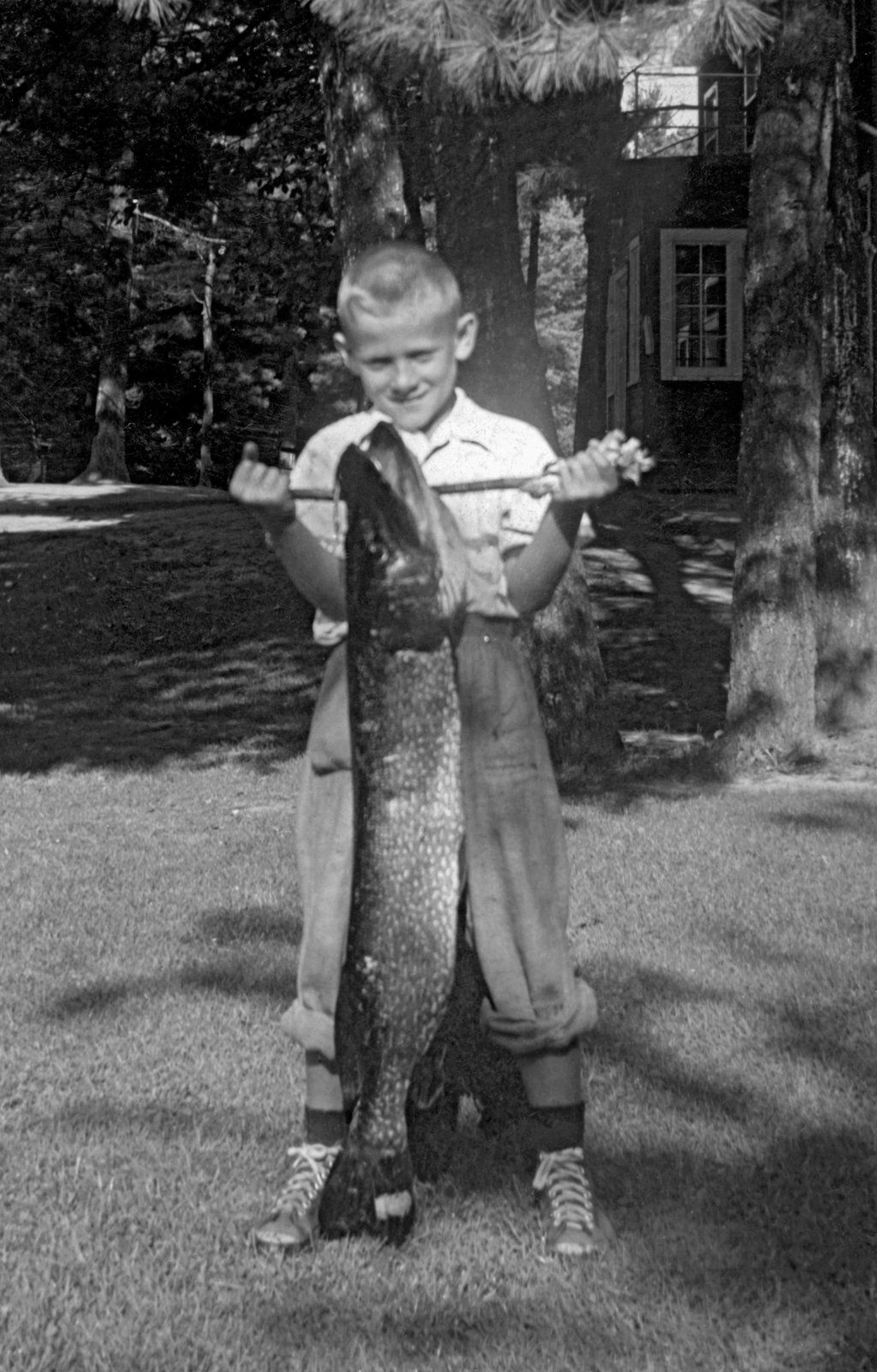 Peter Shea with the 15-pound muskie that he proudly caught in the Ottawa River, Bristol, Quebec, c. 1952.