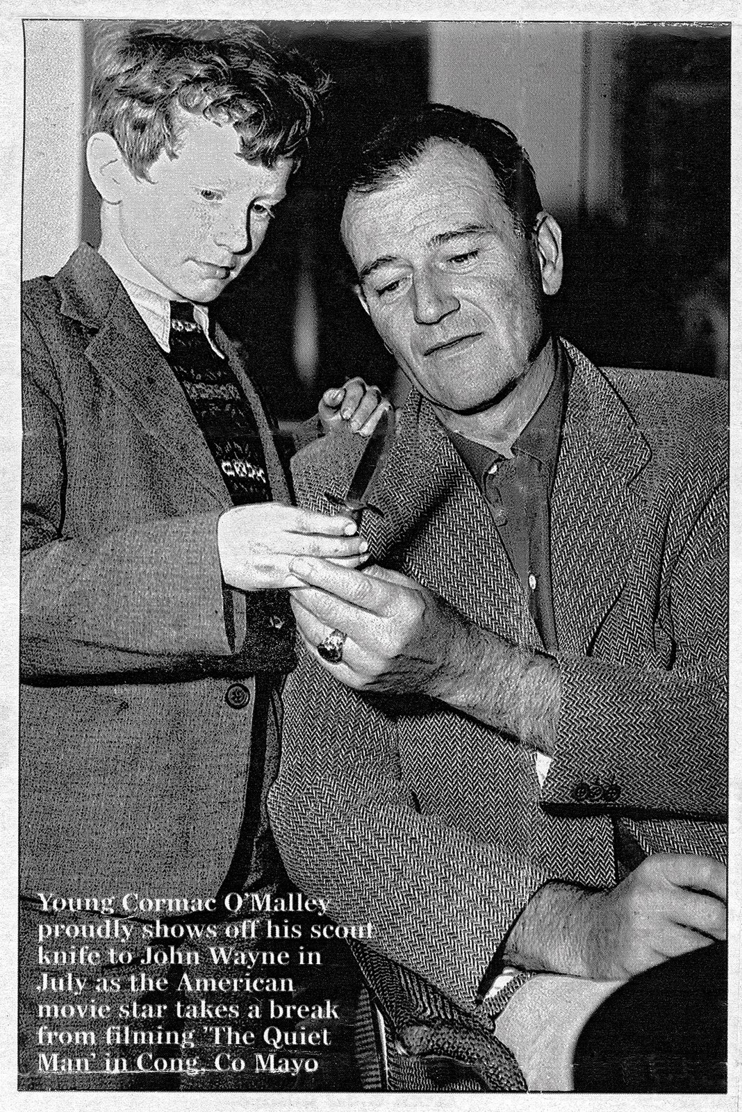 Cormac O’Malley (age 8) shows his scout knife to actor John Wayne on the set of The Quiet Man, County Mayo, 1951.